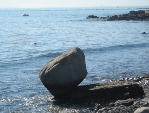 At the edge of the Atlantic Ocean, a large, roughly cubical, chunk of granite balances on one corner.
